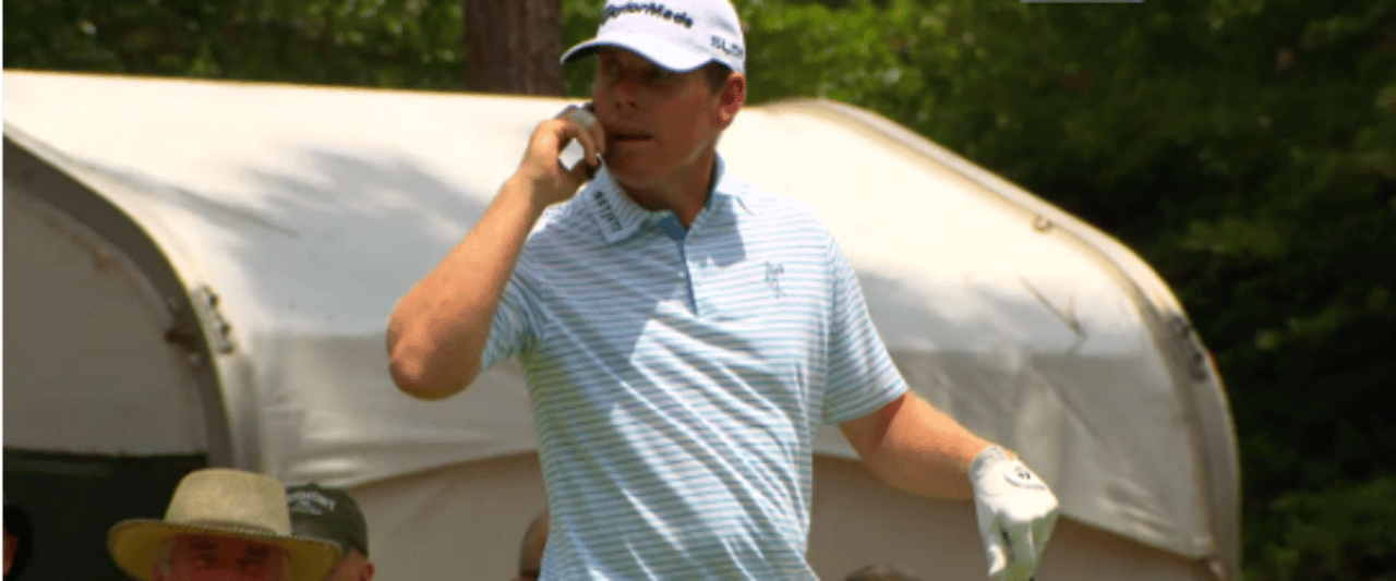 Justin Leonard telefoniert auf der Proberunde der US Open mit dem Handy eines Volunteers.