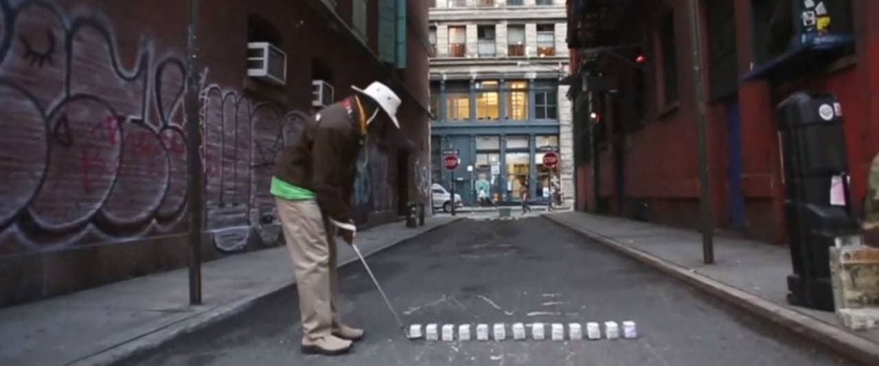 Tiger Hoods Erfindung: Milchkartons statt Golfbälle beim Streetgolf in New York City. (Foto: Screenshot) Tiger Hoods Erfindung: Milchkartons statt Golfbälle beim Streetgolf in New York City. (Foto: Screenshot)