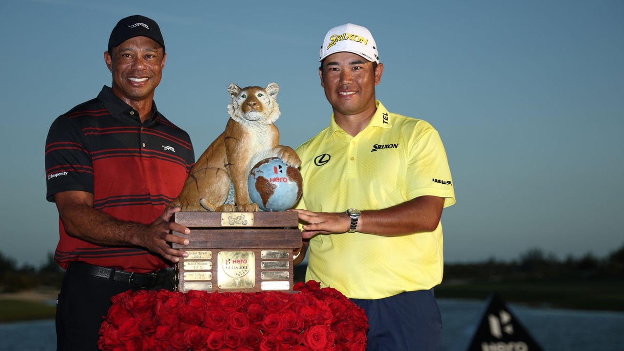 Hideki Matsuyama sichert sich die Trophäe der Hero World Challenge aus den Händen von Tiger Woods. (Foto: Getty)