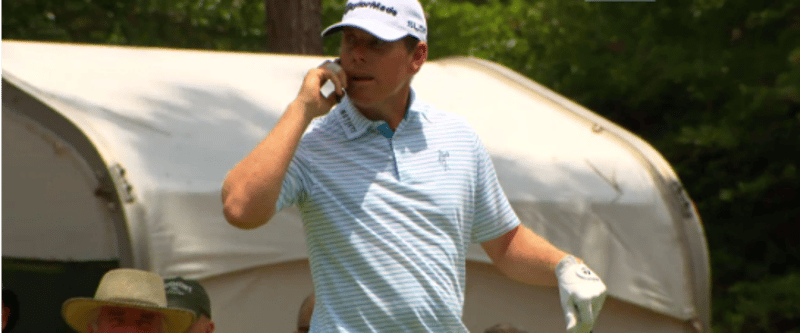 Justin Leonard telefoniert auf der Proberunde der US Open mit dem Handy eines Volunteers.