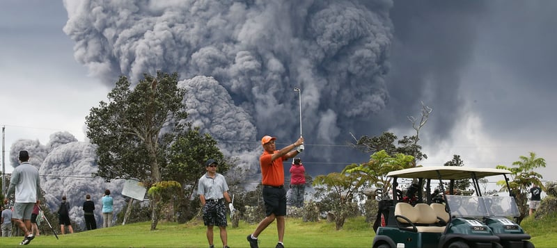 Dieser Golfer auf Hawaii lässt sich auch von einem ausbrechenden Vulkan nicht bei seiner Runde stören. (Foto: Getty)