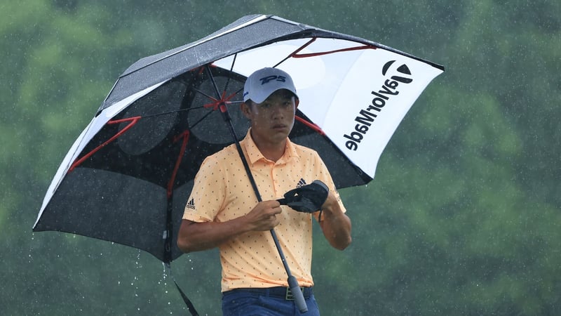 Collin Morikawa schützt sich mehr schlecht als recht vor den Wassermassen. (Foto: Getty)