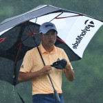 Collin Morikawa schützt sich mehr schlecht als recht vor den Wassermassen. (Foto: Getty)